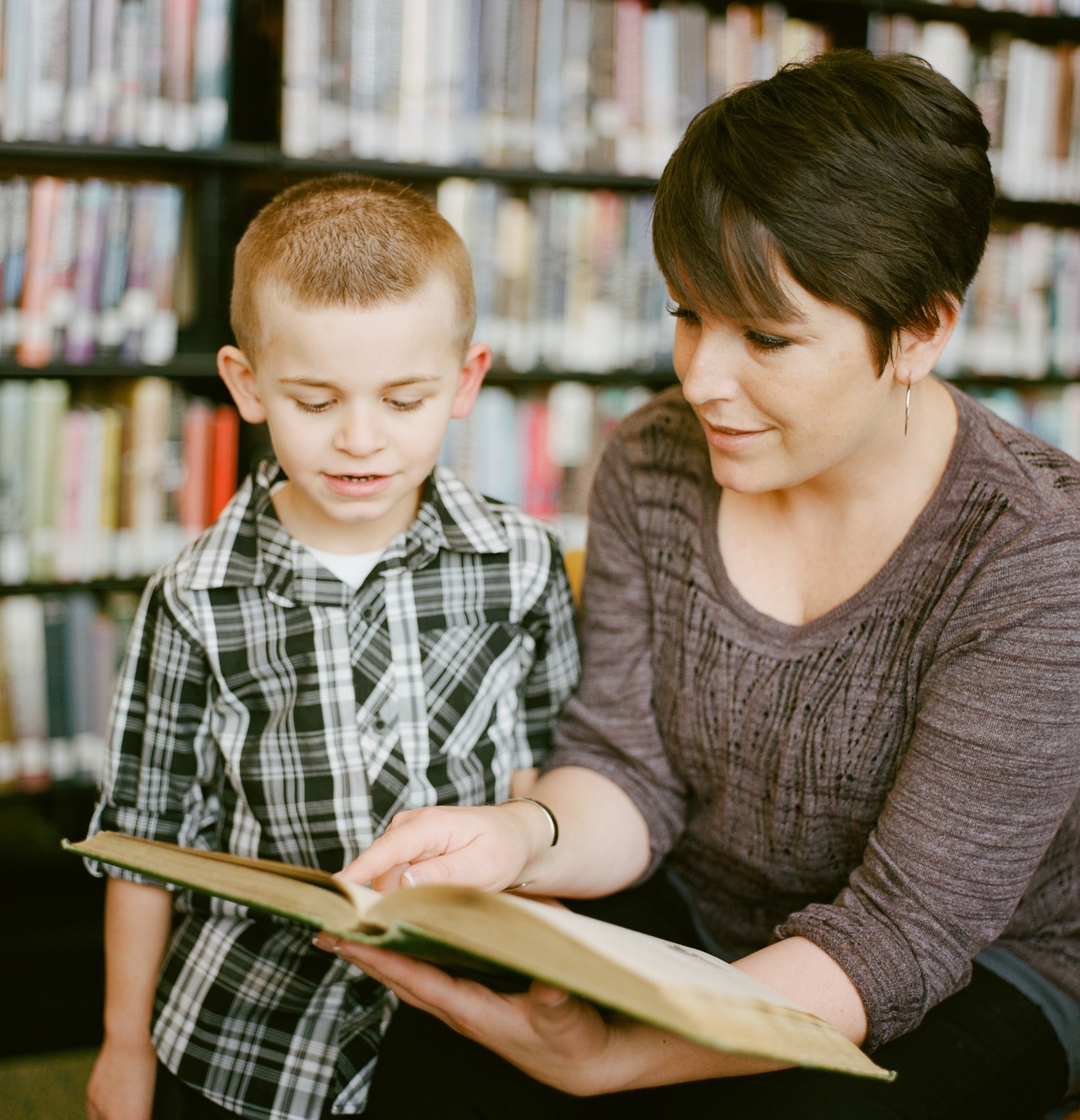 Teacher and boy in library